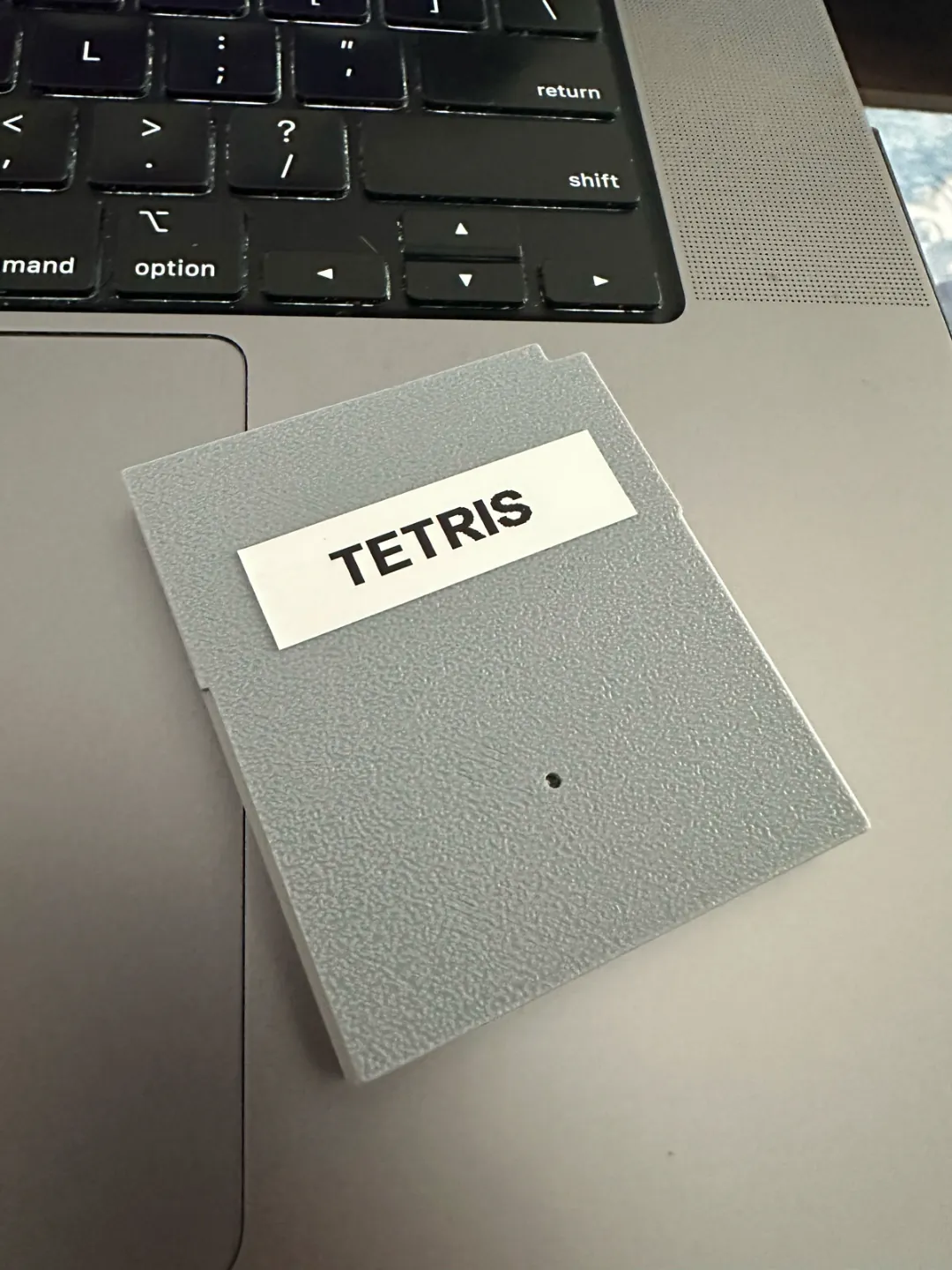 A gray 3D-printed Game Boy cartridge shell with a plain white TETRIS label